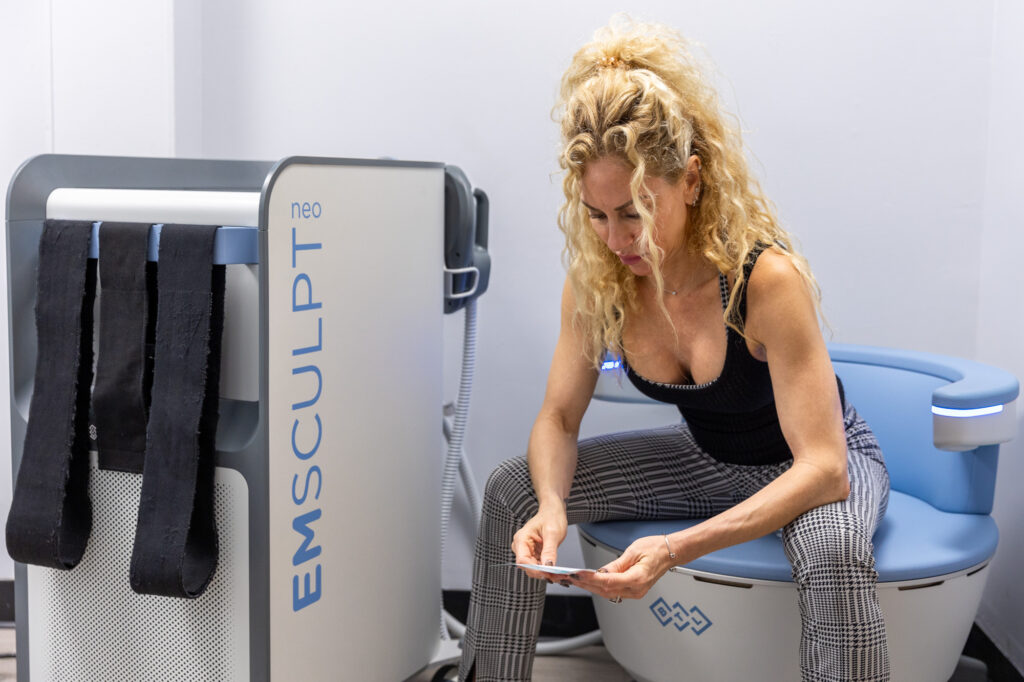 A woman sitting on the Emsella chair for post-partum recovery